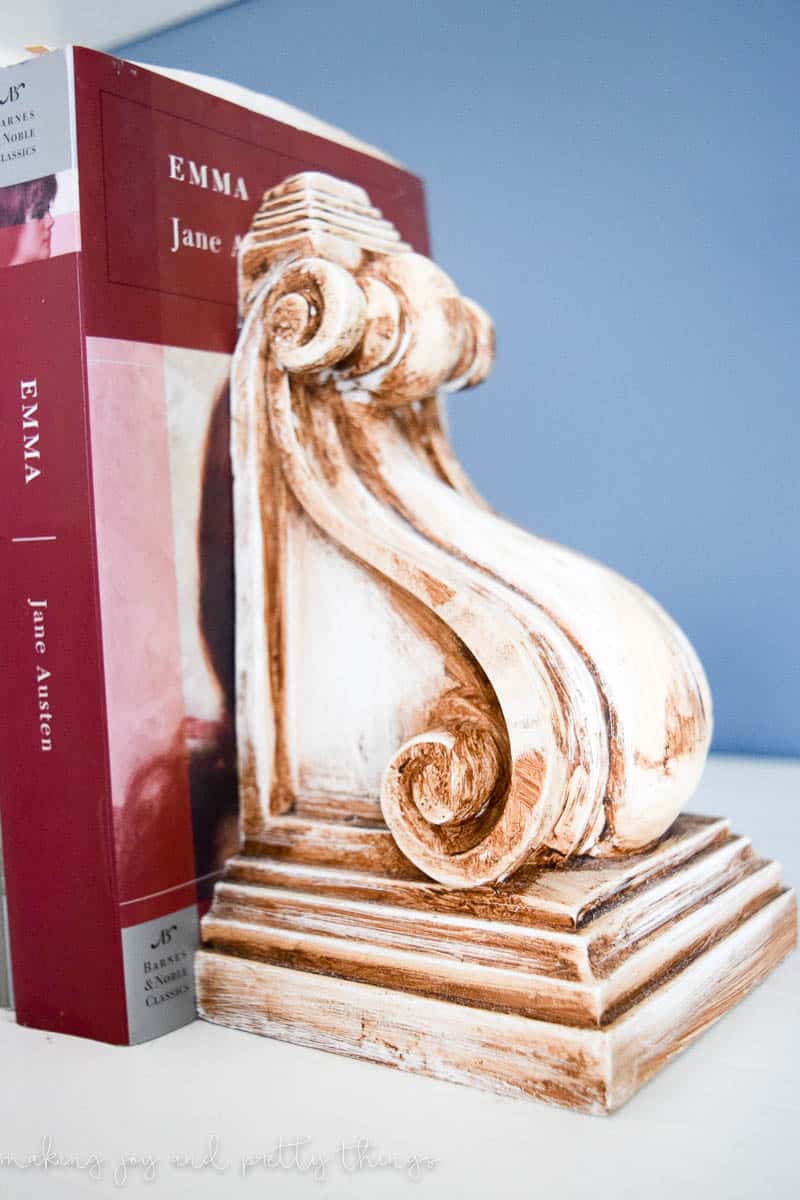 Close up of antique wax done on corbels to give a rustic look and used as bookends on a shelf