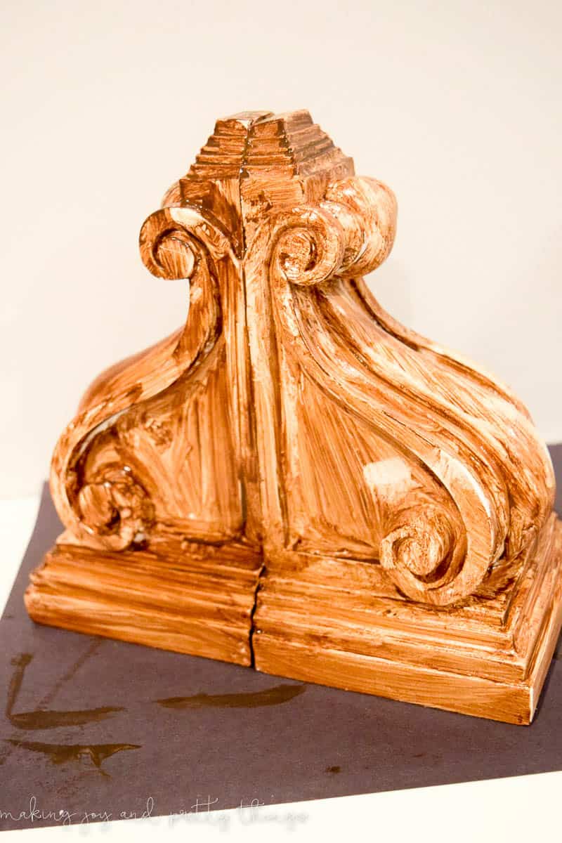 Placing antique wax on corbels to distress them and make rustic corbels to be used as book ends