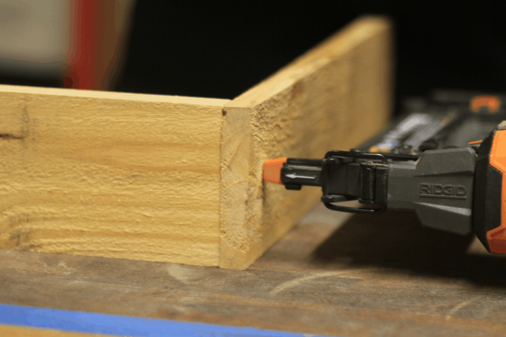 Nailing together a couple pieces of pallet wood with a brad nailer to make a box that will be a DIY pallet crate