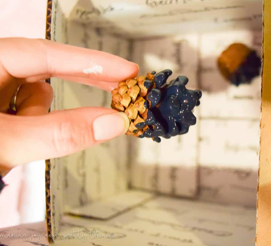 A mini pinecone dipped in chalk paint is a great embellishment for rustic Christmas gift wrap.