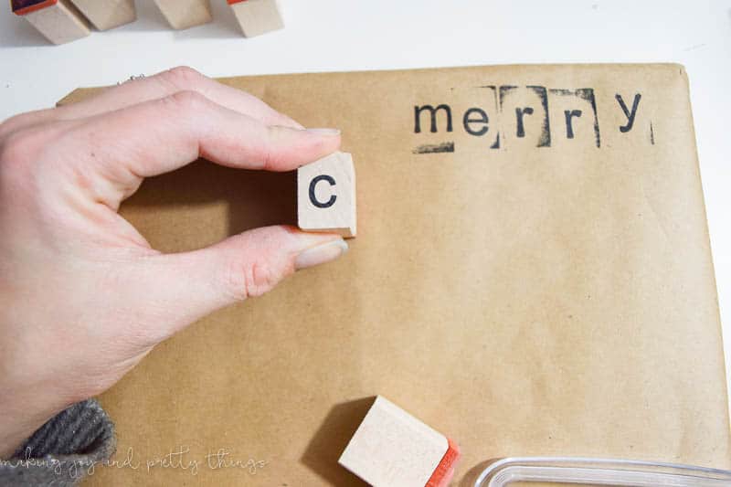 Use letter stamps to embellish the brown kraft wrapping paper to give Christmas gifts a rustic touch.