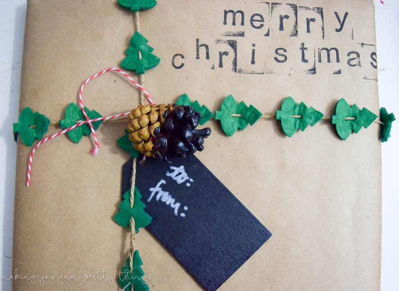 These adorable rustic gift wrapping ideas use pinecones and stamps to add a rustic touch to your Christmas gifts. Add Christmas tree garland and a gift tag for a finishing touch.