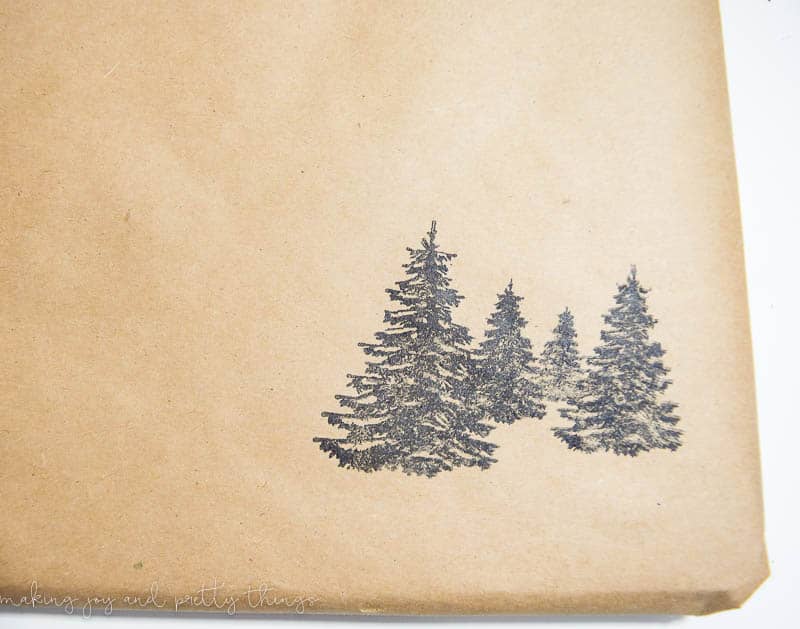 Black pine tree stamps on brown craft paper makes perfect DIY rustic gift wrapping.
