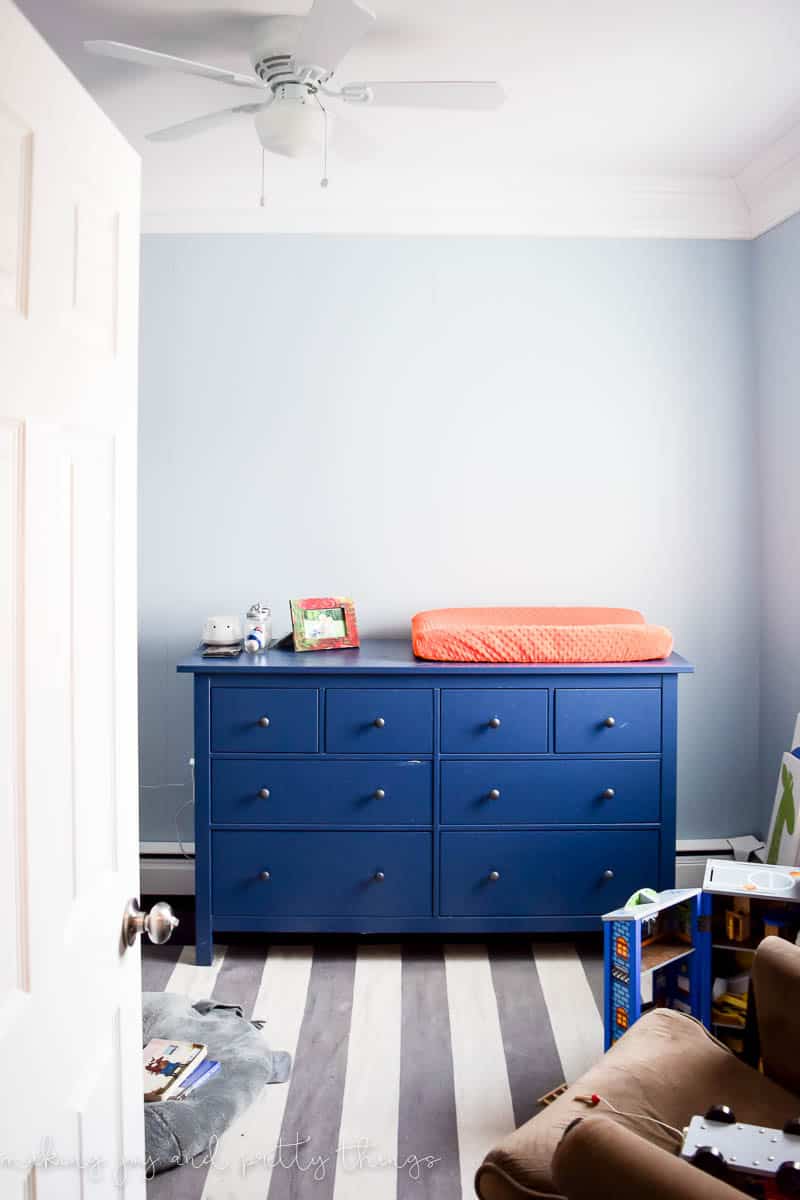 Girls nursery with standard colors and a typical rug and rocker chair that is before renovation in a farmhouse nursery decor style