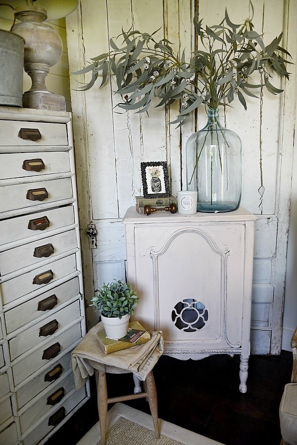 This antique radio cabinet is painted with a ivory paint color with pink undertones from Magnolia Home paint line called Antique Rose. It looks great in this farmhouse style room.