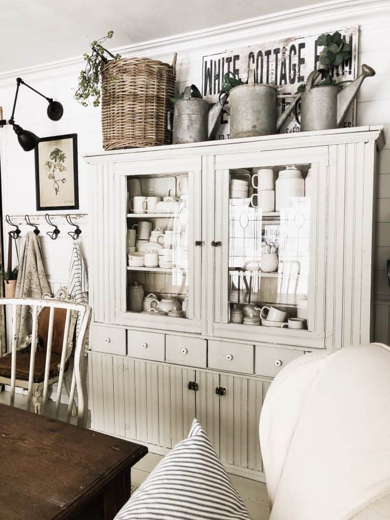 The griege paint color that is used on this dining room hutch is called Gatherings by Magnolia Home. 