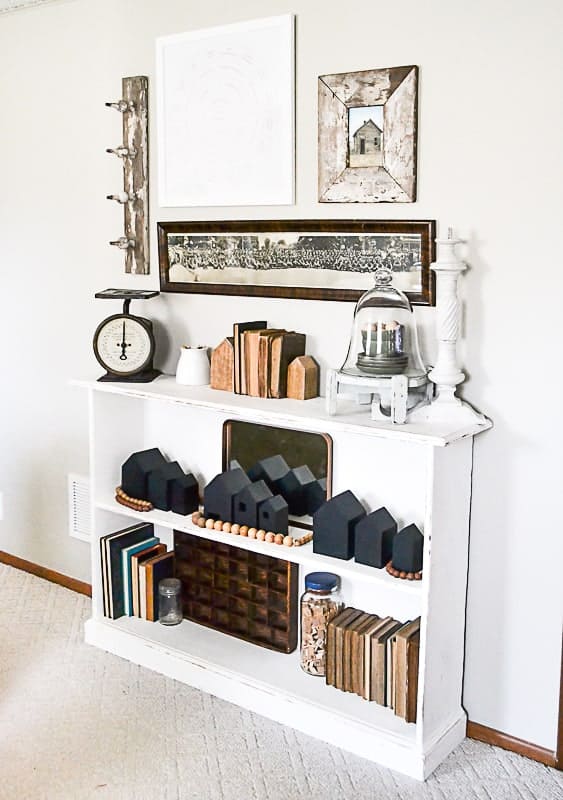 How cute is this bookshelf in farmhouse styled living room with Gatherings paint color painted on the walls?