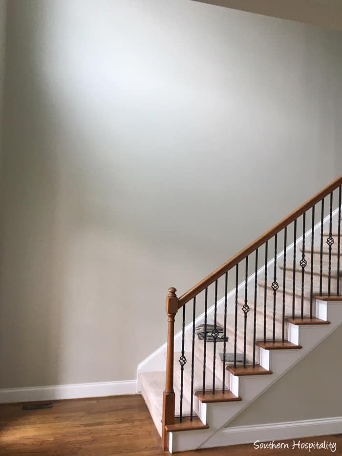 Gatherings by Magnolia Home is the perfect paint color for the walls in this 2-story entry and stairwell. It looks great with the white painted trim and baseboards. 