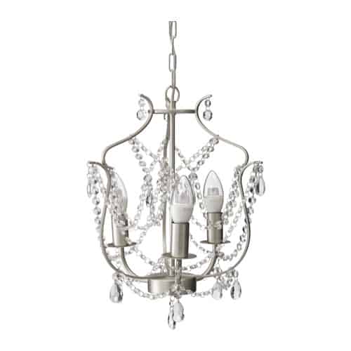 A silver IKEA chandelier with strings of crystals and four candle-style light pillars.