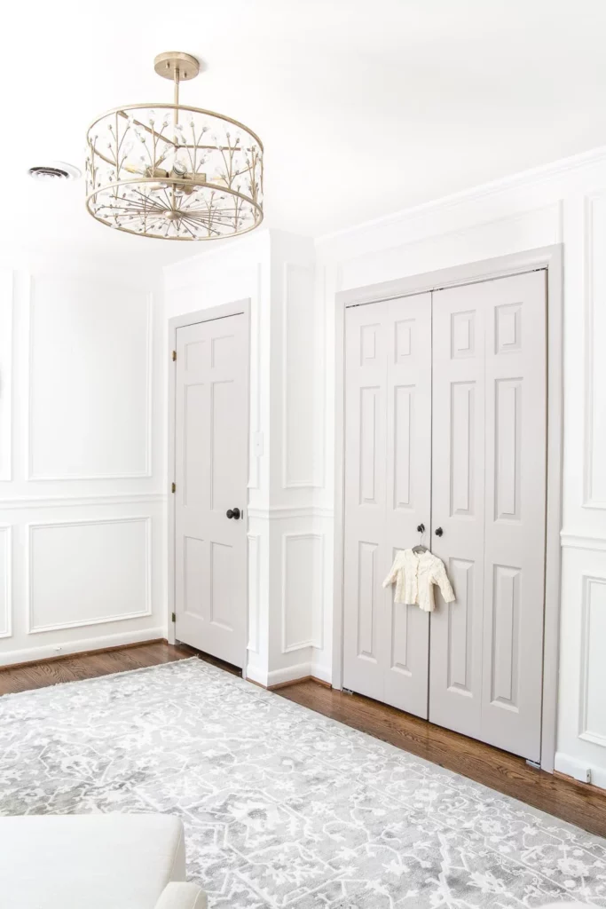 Magnolia Home True White is the bright white paint color painted on the walls in this nursery paired with a light gray color on the doors and trim.
