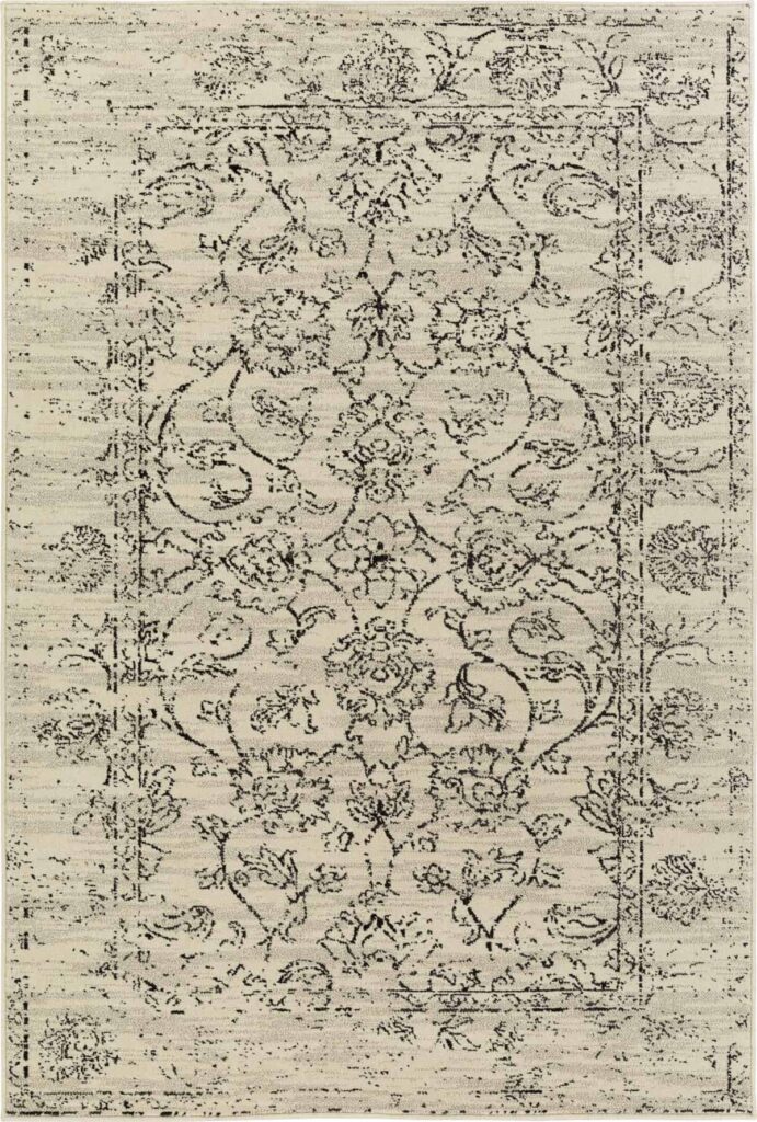 A large patterned area rug with a tan and cream base color and a very faded ornate oriental patten throughout.