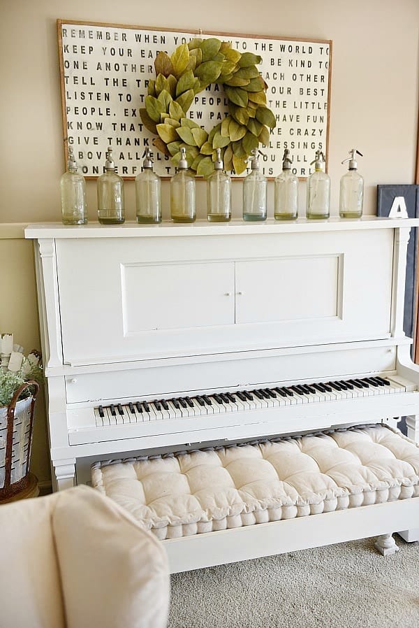 This antique piano is painted with True White by Magnolia Home, a bright white from Joanna Gaines' paint company. It looks great styled in this farmhouse living room.