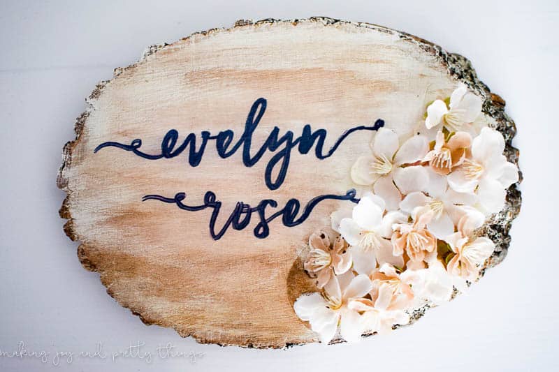 Completed diy nursery name sign with flowers and vintage decor paint to give a farmhouse look