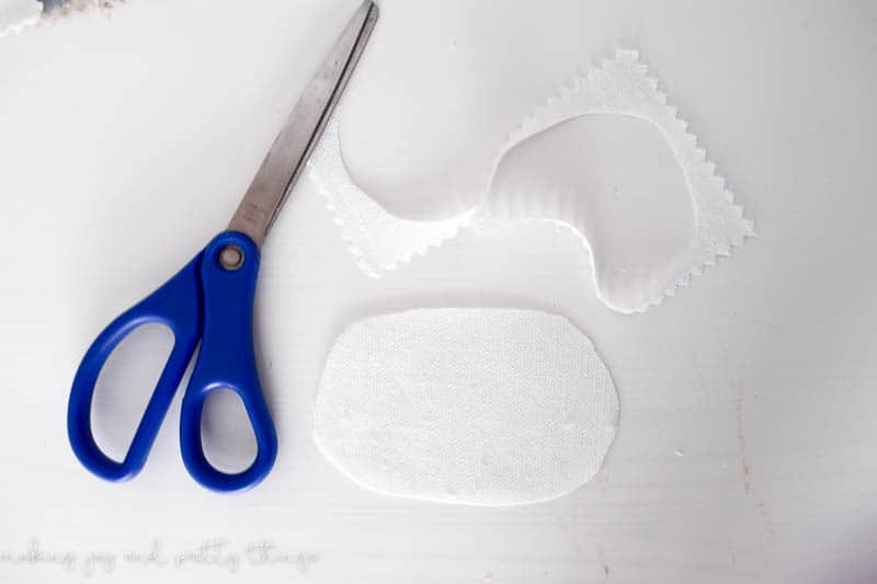 Cutting ovals into the linen samples to wrap into diy fabric flowers to put onto a garland with hot glue