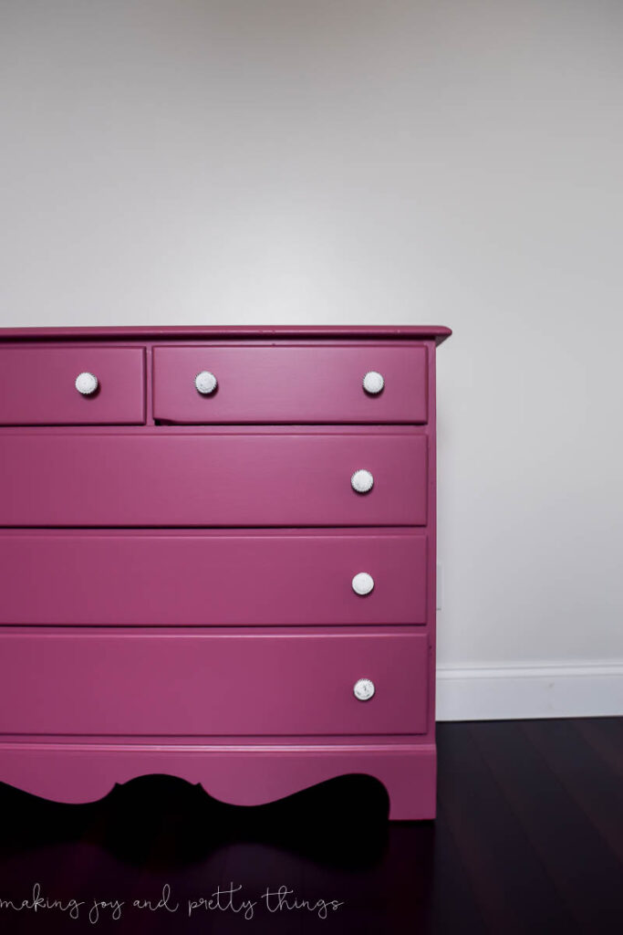A freshly painted DIY pink dresser painted a darker mauve pink color. Each dresser has a white knob handle.