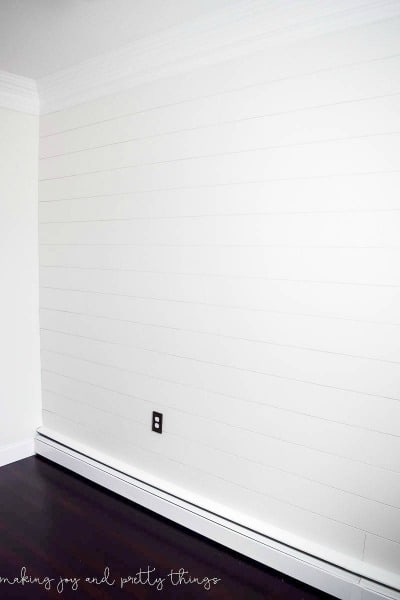 Plain white shiplap wall in bedroom 