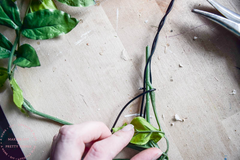 Wrap faux flowers from Michaels around a decorative wire loop using wire to attach the stems and greenery