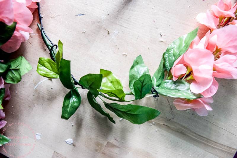 spring farmhouse wreath using pink flowers and greenery as a DIY project for spring season