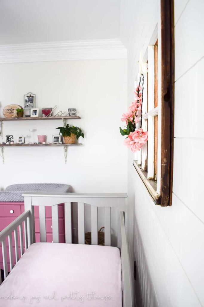 Shiplap accent wall painted white to add a classic farmhouse feel with a vintage frame and rustic shelves 