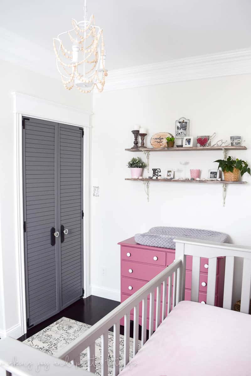 Another view of our girl's farmhouse style nursery - the closet, changing table and decorative shelves, and baby's crib.