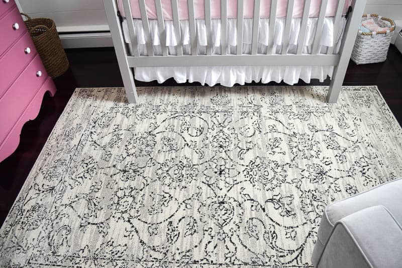 Floral rug used for a farmhouse nursery decor option over a hardwood floor in a light cream grey color