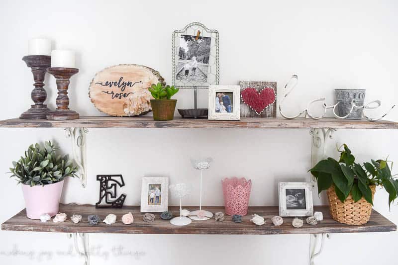 Using multiple different decor pieces on rustic shelves to add variety to the farmhouse girls nursery 