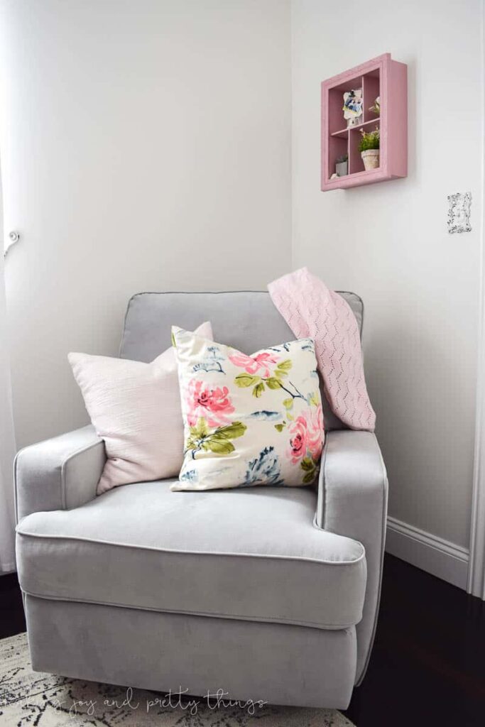 Another great farmhouse nursery idea is to have a rocker chair with some floral pillows to make the room more cozy