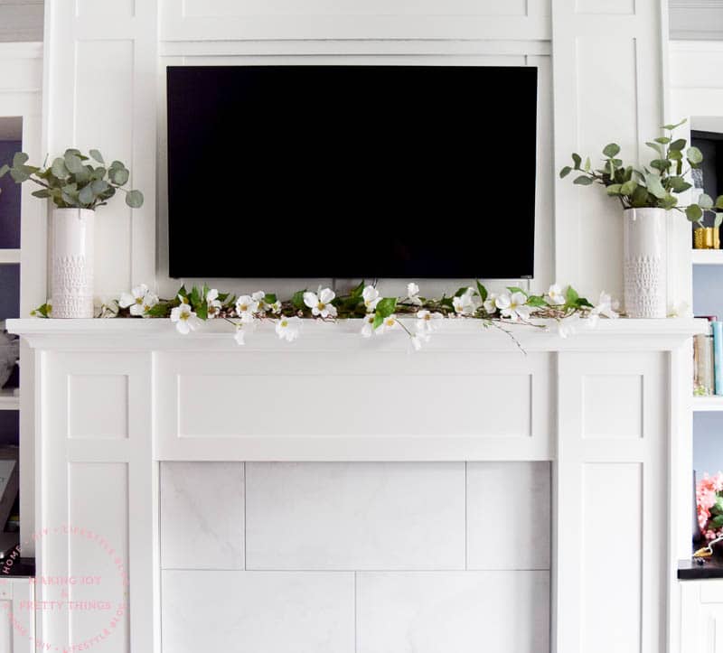 Use some spring garland around your mantel to give farmhouse style notes and decor around a tv