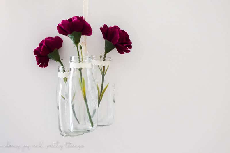 Completed decor using ribbon and flowers to create a farmhouse style DIY hanging jars decoration