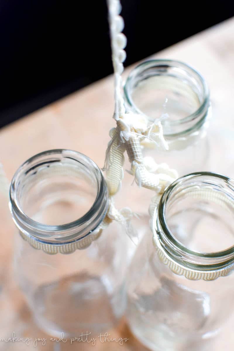 Combined lacy ribbon assortment attached to jars to make a decor item that can be hung up 