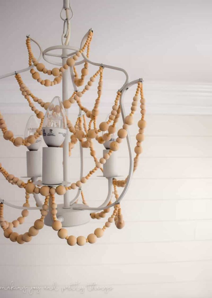 Learn how to make this fun farmhouse style diy wood bead chandelier in just a few easy steps.