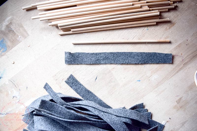 Preparing the felt to wrap around dowels to create a unique look for a DIY letterboard for a newborn baby