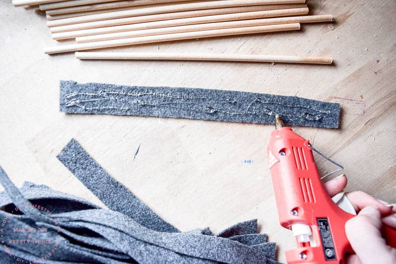 Using a hot glue gun on felt creates a nice bond to wooden dowels that dries quickly and efficiently