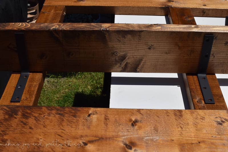 Adding shelves to an exterior frame for potted plants on a DIY vertical herb garden