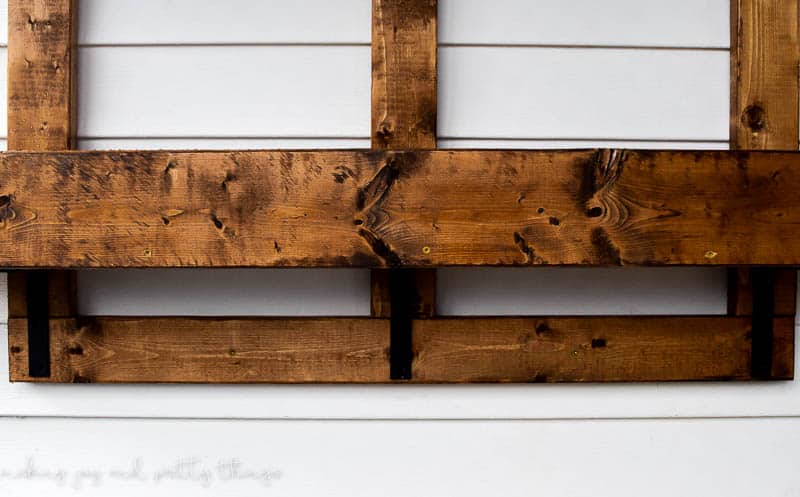 Anchor the frame to the siding before adding herbs and potted plants to your DIY vertical herb garden and planter
