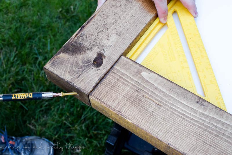 Use a square to get nice 90 degree angles when assembling a wood frame for a DIY vertical herb garden 