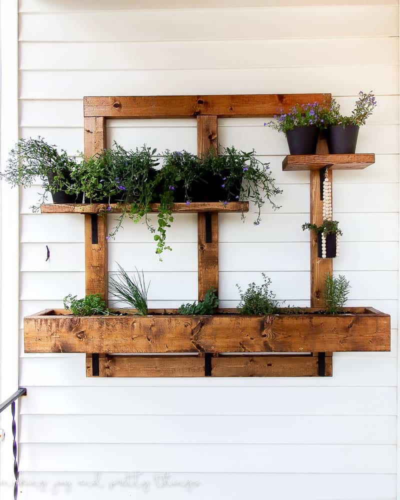 Complete DIY vertical herb garden hung on exterior siding that provides a lot of options for plants in pots and planter