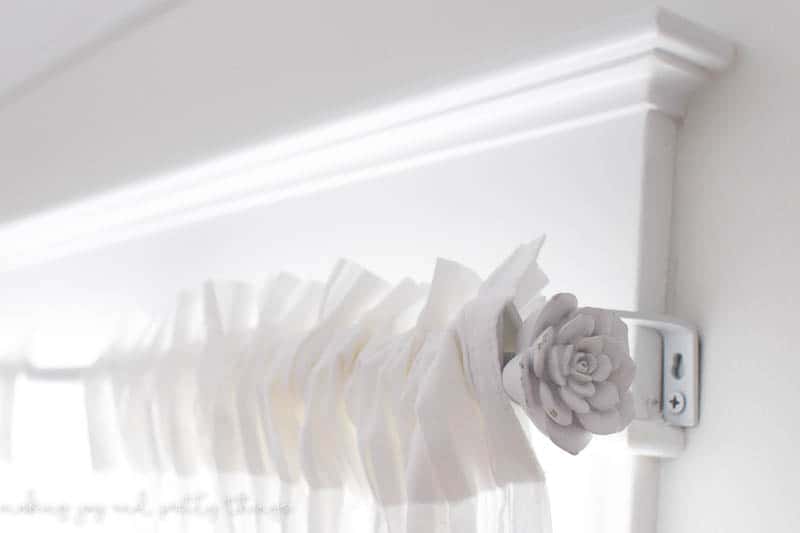 White curtain rods updated for farmhouse style baby girls nursery with Rose knob from hobby lobby 