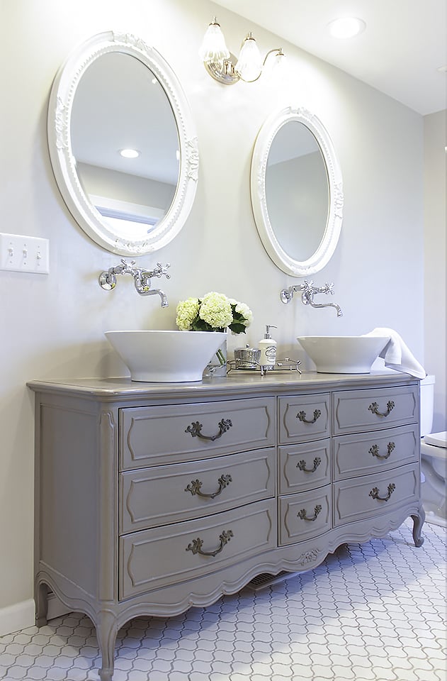 Vintage dual vanity made from an old dresser on top of tile with wall mount faucets