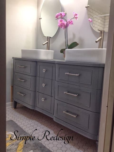 Beautiful grey colors contrasted with white sinks and brush modern faucets give this bathroom a modern old world feel
