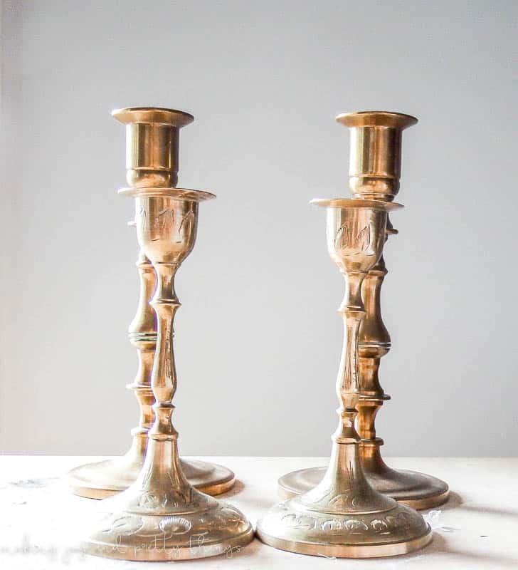 A set of four thrift store candleholders updated to a shiny gold finish using an easy to use wax metallic finish.