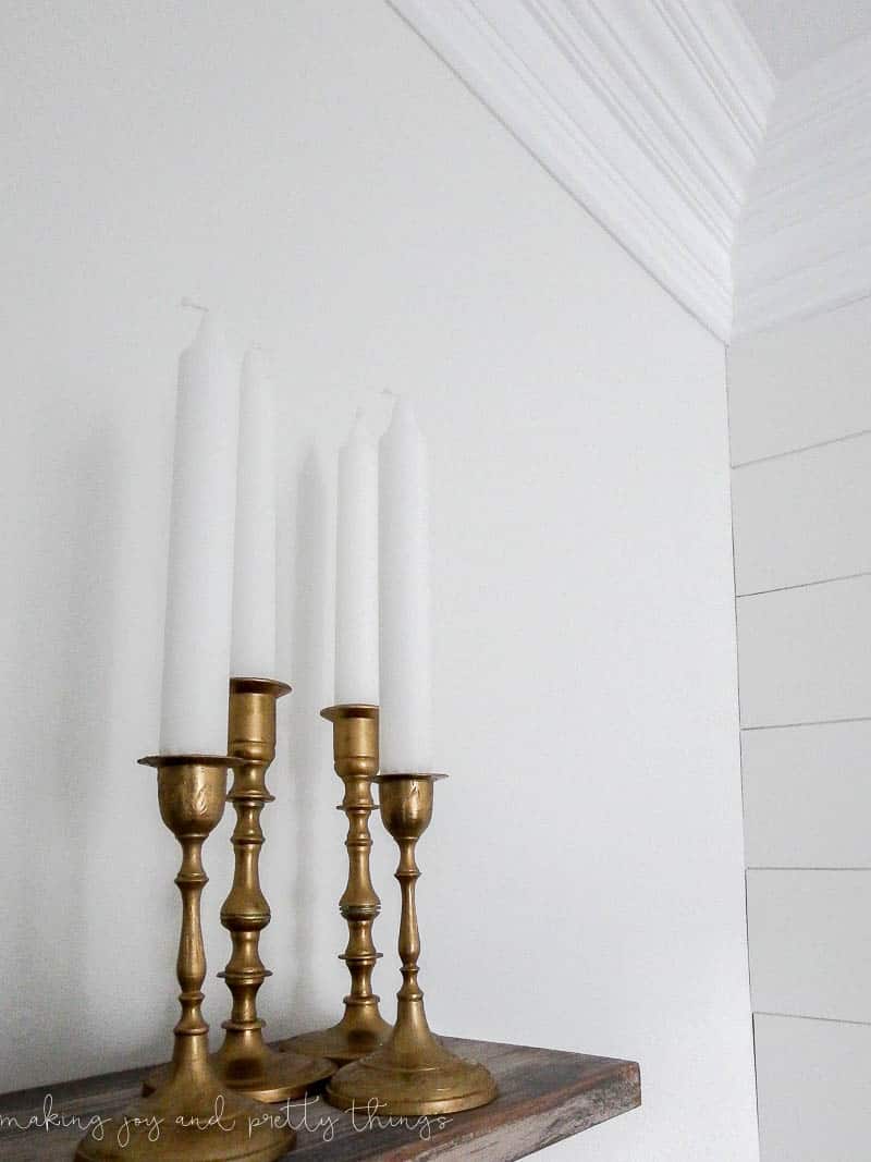 A set of four gorgeous gilded gold candleholders have a new, shiny finish thanks to some metallic gilding wax for an easy thrift store candleholder makeover.