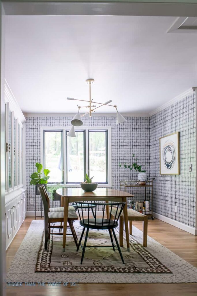 A neutral patterned rug is layered over a jute sisal rug in the dining room.