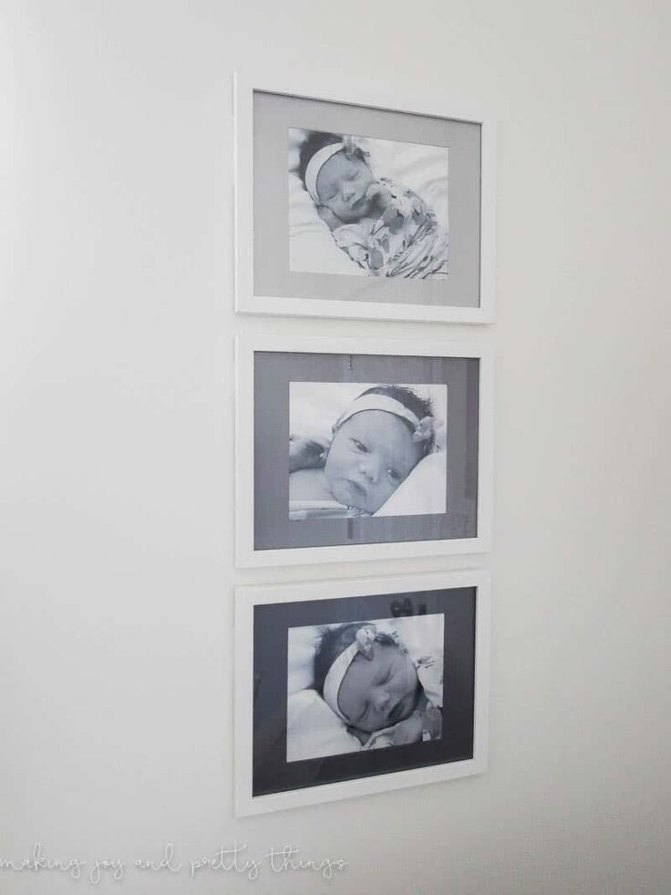 Three picture frames with painted mat boards in different shades of grey hang on a white wall.