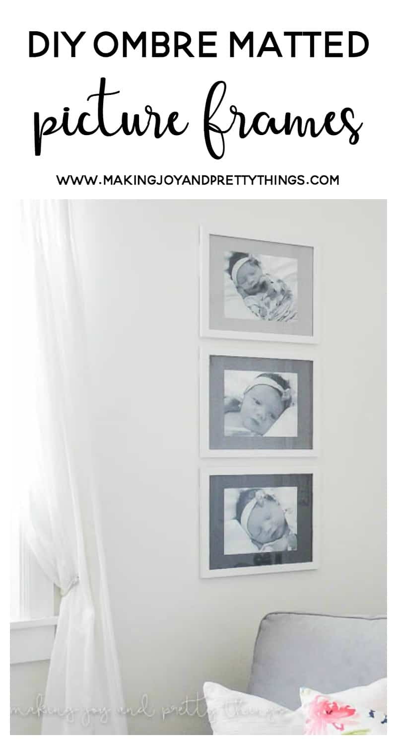 A set of three framed black and white photos of a newborn baby hang on a white wall next to a window. The picture mat boards within the frame are painted different shades of gray, creating an ombre effect from top to bottom.