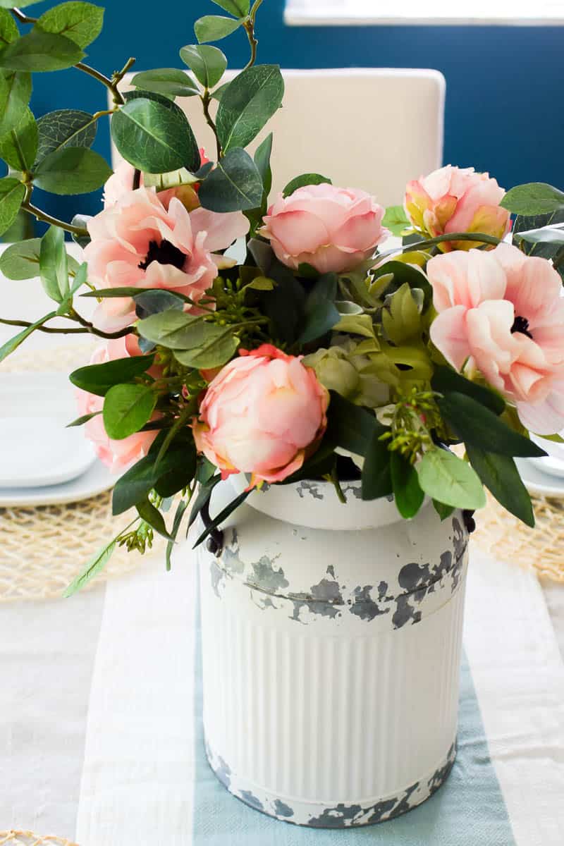 Close up of farmhouse floral arrangement with a chalky distress vintage milk can