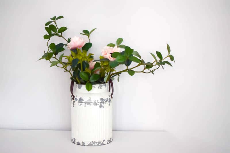 Adding pink and white roses interlaced in the vintage milk can decor to bring beauty to it