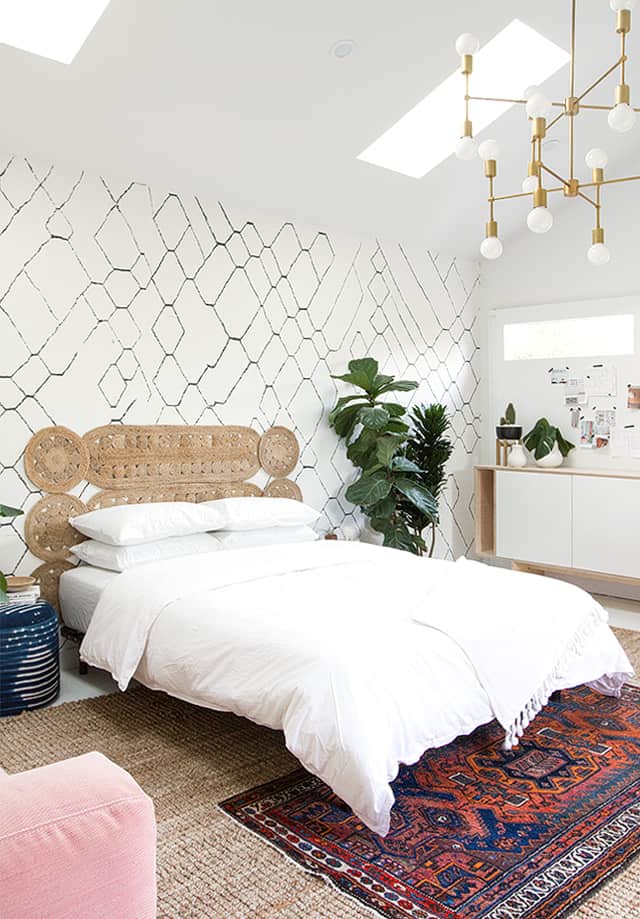 Here is a photo of a Sisal rug with a southwestern-patterned vintage rug on the bedroom floor.