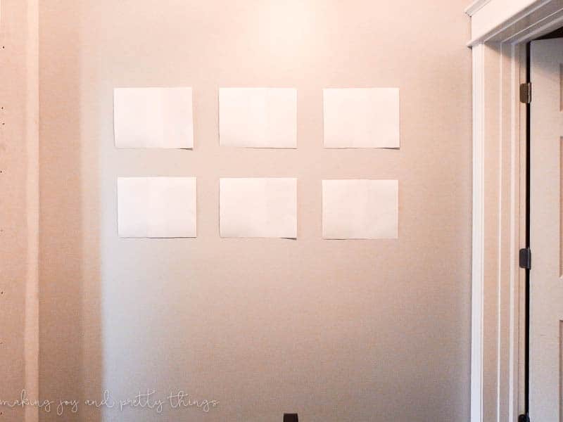 Plan out your pictures for a gallery wall by cutting some paper to the size of your frames and put them up on a wall 