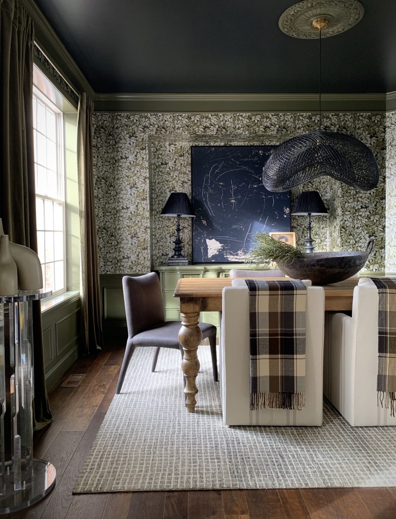 A photo of a traditional dining room with stunning green wallpaper.